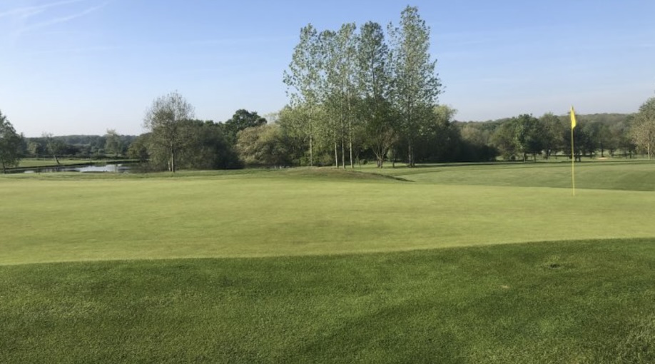 Billingbear Park Golf Course, Berkshire, - Golf Green with Flag, trees and lake in the background
