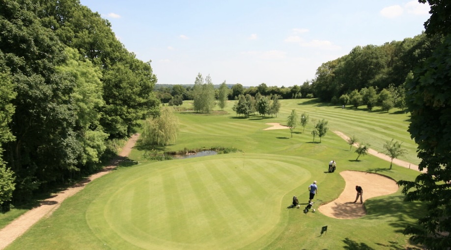Deanwood Park Golf Club, Berkshire - Aerial image overlooking Golf Course Green with players in bunker