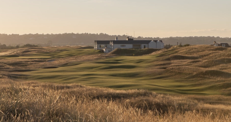 Rye Golf Club, East Sussex, - Low level landscape golf course greens and fairways with small clubhouse in the distance