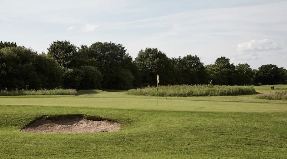 Styal Golf Club, Cheshire,- Golf course green with bunker to front, tree lines to background fairway