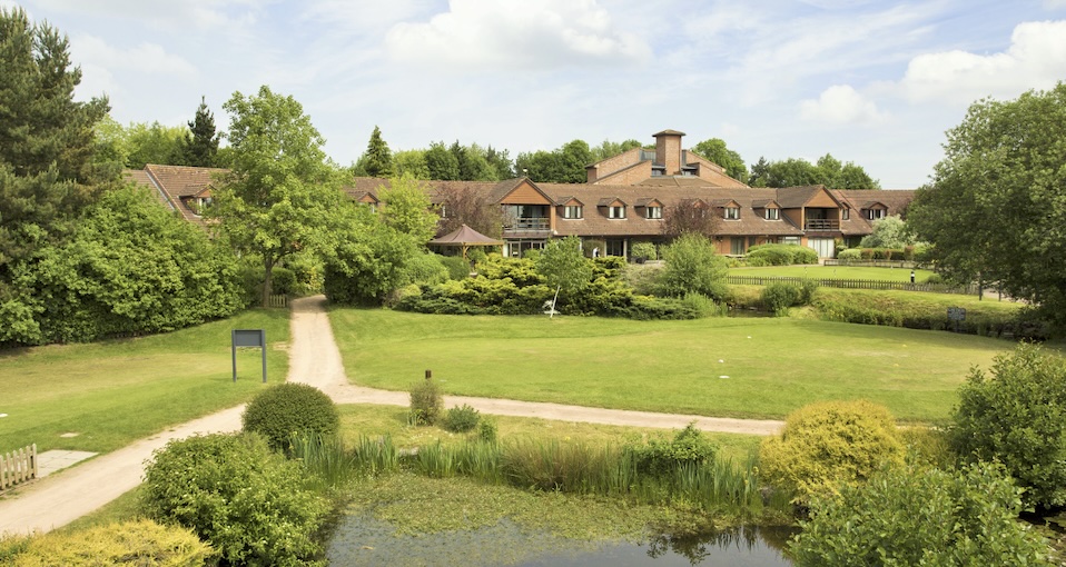 Abbey Hotel Golf & Country Club, Worcestershire - landscape view of golf course looking back to clubhouse surrounded by trees and putting green