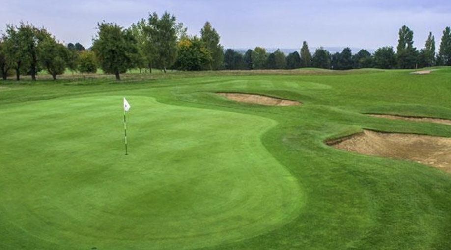 Birchwood Park Golf Centre, Kent, - golf course green with bunkers , trees lining the fairway in the distance