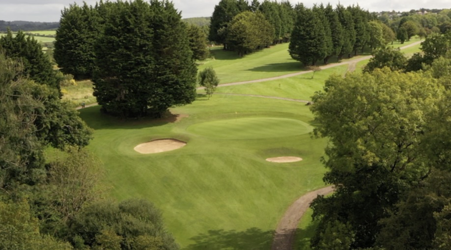Brynhill (Barry) Golf Club, South Glamorgan overview of golf course green and fairway surronded by trees and 2 bunkers