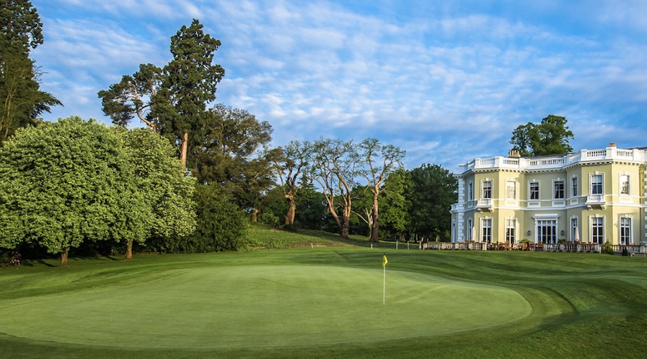 Burhill Golf Club, Surrey, - View of golf course overlooking green with trees and clubhouse in backdrop