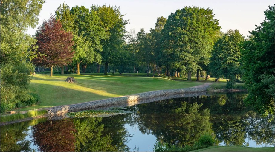 Golf Club England - Cottesmore Golf Club, West Sussex, UK - Golf Vouchers Cottesmore Golf Club, West Sussex - view of golf course looking over lake to fariway and green within trees