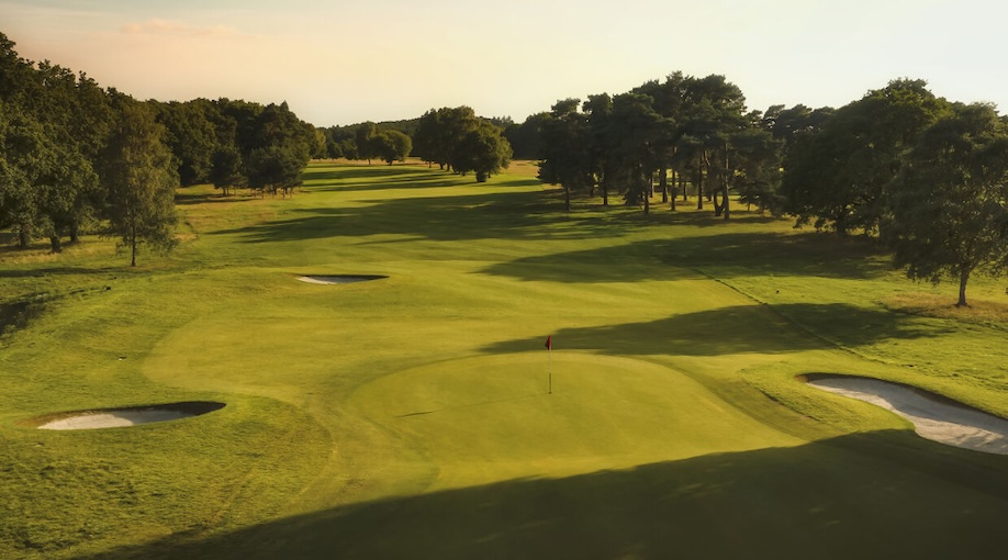 Farnham Golf Club, Surrey, - View of golf course from behind green with bunkers looking down tree lined fairway back to tee