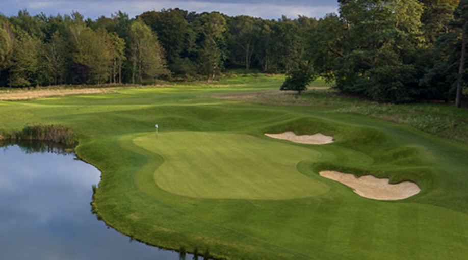 Royal Norwich Golf Club, Norfolk, - View overlooking golf course green on edge of lake with 2 bunkers and surronded by trees