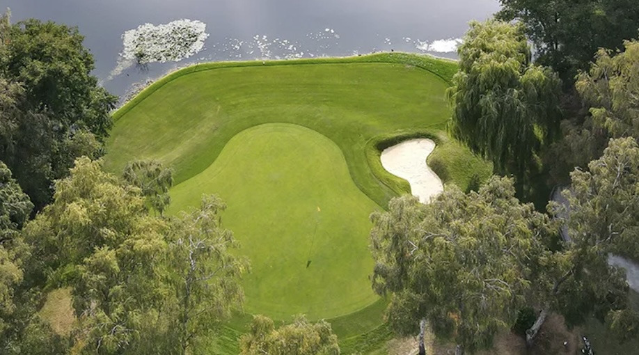 Silvermere Golf Club, Surrey, - aerial view of golf course green with trees, bunker and large lake water feature