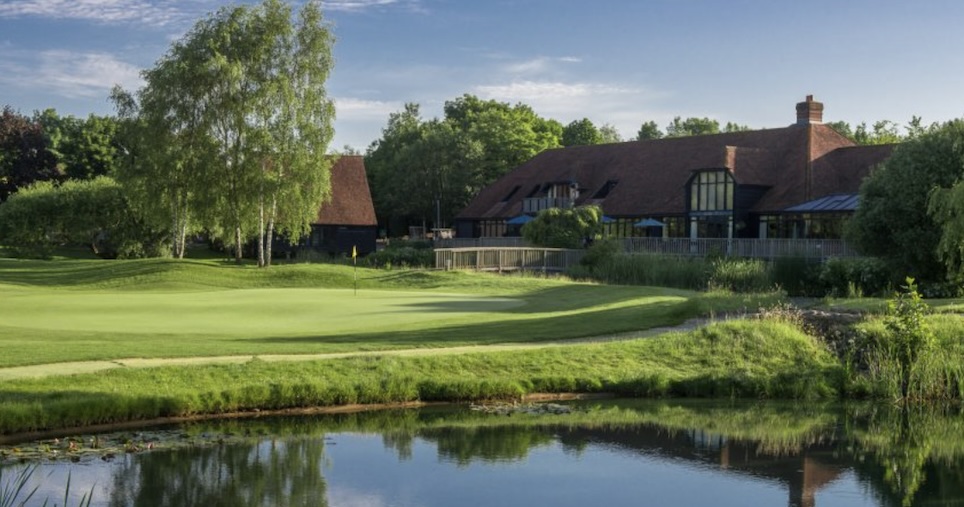 GVO - South Winchester Golf Club, Hampshire - landscape view of golf course clubhouse with putting green and lake in front