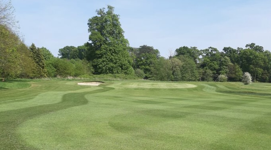 Southwick Park Golf Club, Hampshire - landscape view of golf course putting green with bunker and trees lining the background