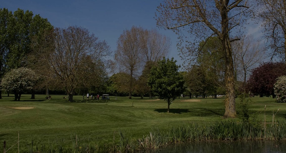 St Augustines Golf Club, Kent, - view of golf course green and fairway among trees from across pond water feature