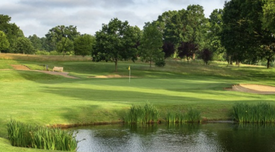 Windlesham Golf Club, Surrey - view of golf course looking over lake to green with bunker and trees lining the backdrop