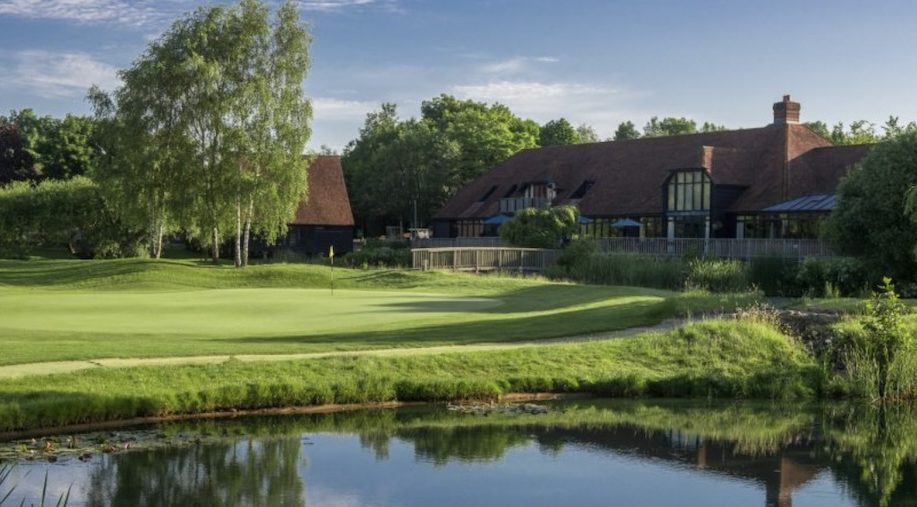 GVO - South Winchester Golf Club, Hampshire - landscape view of golf course clubhouse with putting green and lake in front